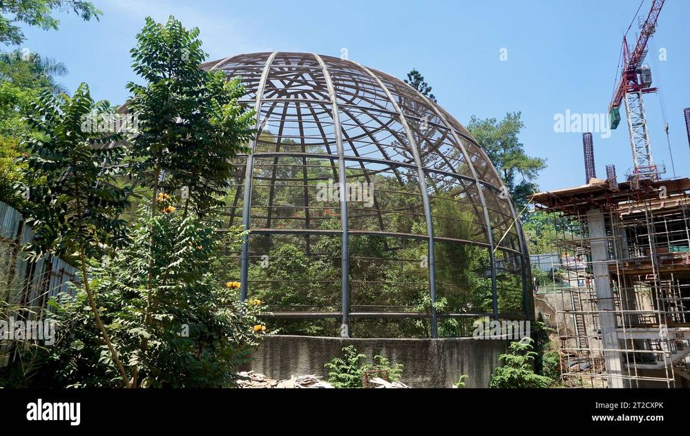 large-metal-dome-aviary-for-bird-conservation-next-to-a-building-construction-site-2T2CXPK.jpg